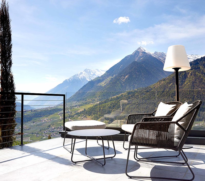 Genuss auf der Terrasse Gemütliche Gartenmöbel auf der Terrasse mit Panorama in die Berge