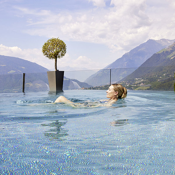 Eine Frau schwimmt im Panorama-Pool des Hotel Das Sonnenparadies in Schenna